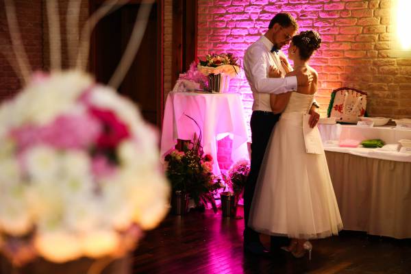 Brautpaar bei Hochzeit in festlich beleuchtetem und geschmücktem Saal